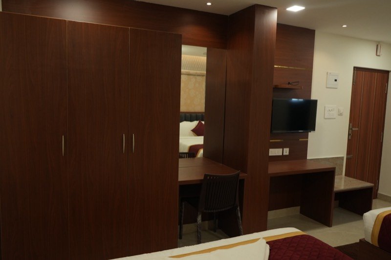 Teak wardrobes, desk and television panel in a Premium room